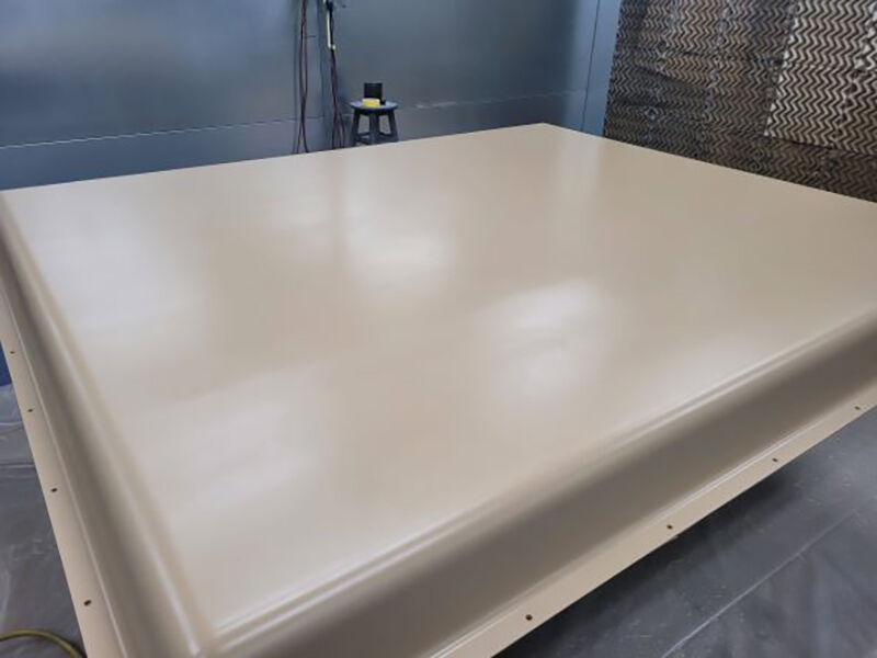 Large ground-based X-band radome for military end-use. Radome is in a paint booth with a freshly painted beige surface.