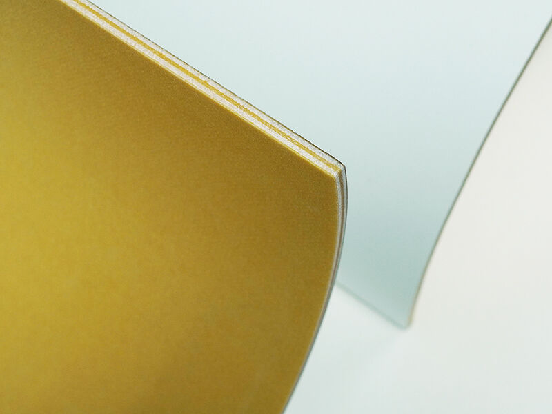Cropped image of two C-sandwich curved panel radomes showing the edge detail. Interior of the curve is yellowish in color. Outside is painted white. They are on a white background.