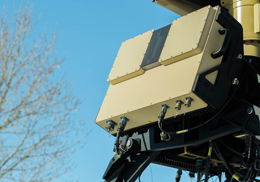 Picture of a section of Numerica's Spyglass radar system outdoors with a blue sky, displaying the radome covers in use.