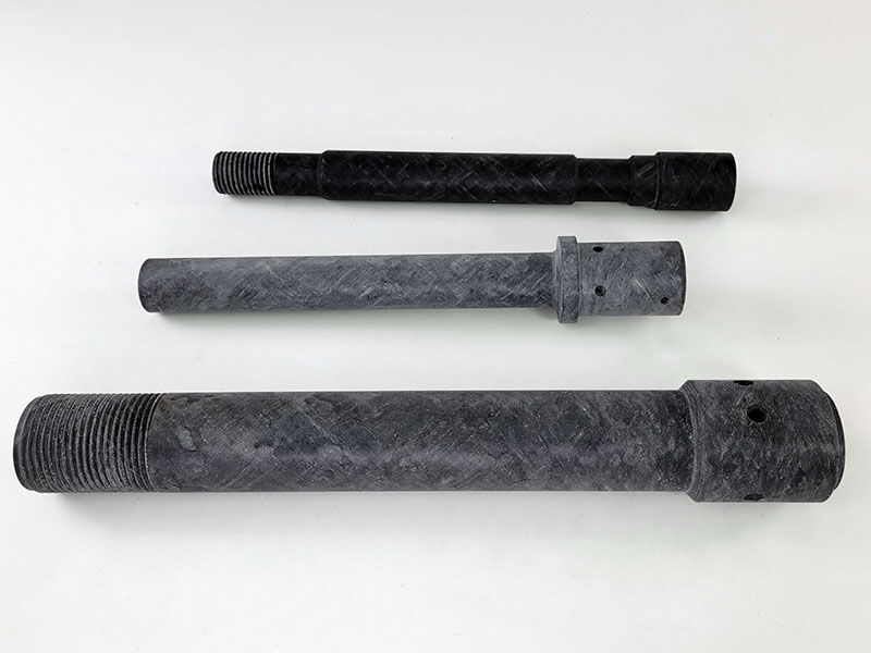 Three frac plugs laying on their sides on a neutral background 