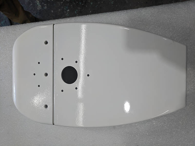 Radome prototype, painted white, sitting on white surface. 