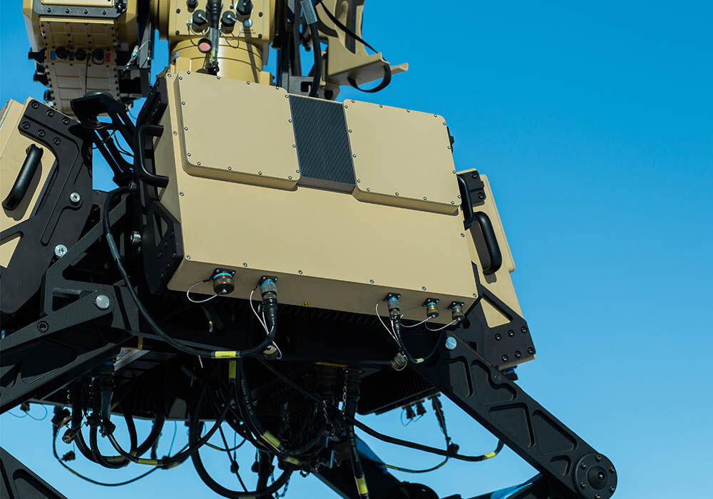 Close-up picture of Numerica's Spyglass radar system outdoors with a blue sky, displaying the radome covers in use.