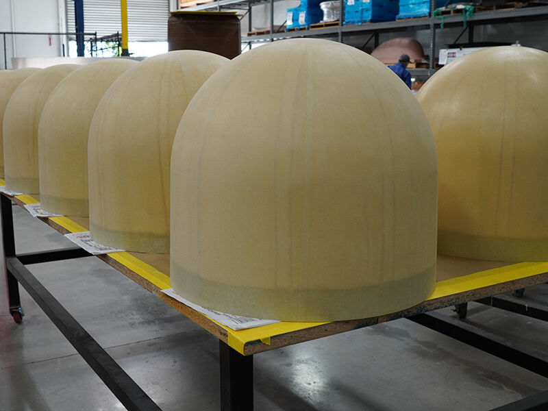 A series of radomes sitting on a table in a warehouse before being taken into an area for coating.