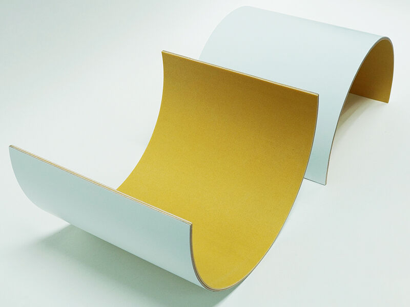 Image of two C-sandwich curved panel radomes, up with the interior facing up and one sitting interior down on the table. Interior of the curve is yellowish in color. Outside is painted white. They are on a white background.